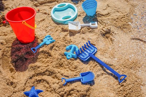 Free Vibrant beach toys scattered on sandy shore, perfect for summer fun. Stock Photo