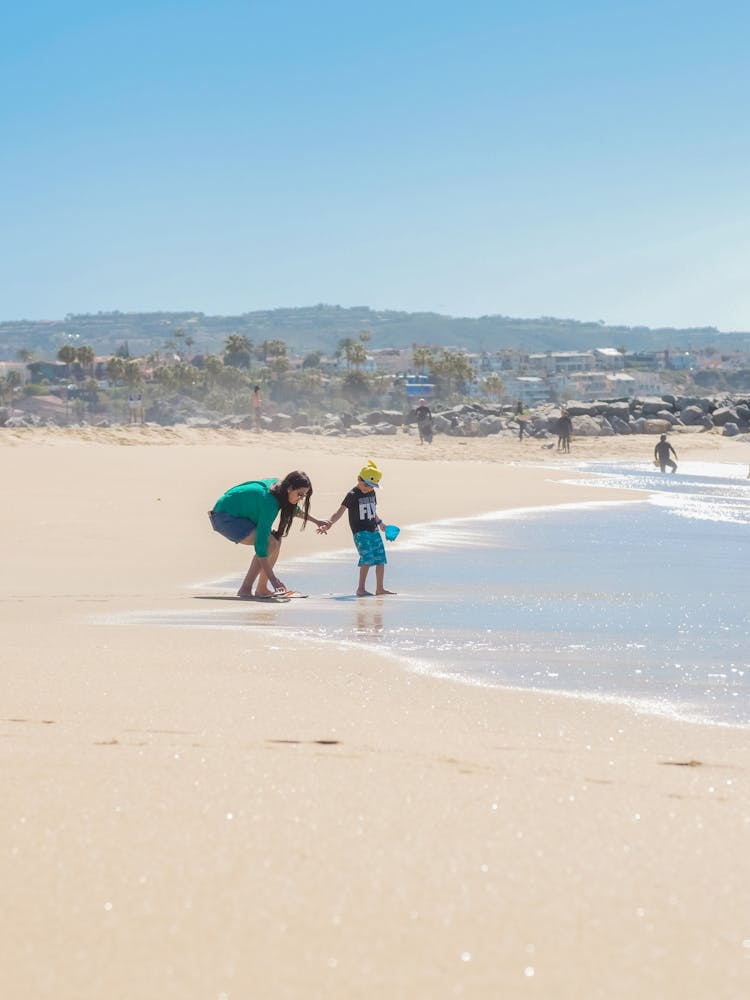 A Mother Playing With Her Son At The Beach