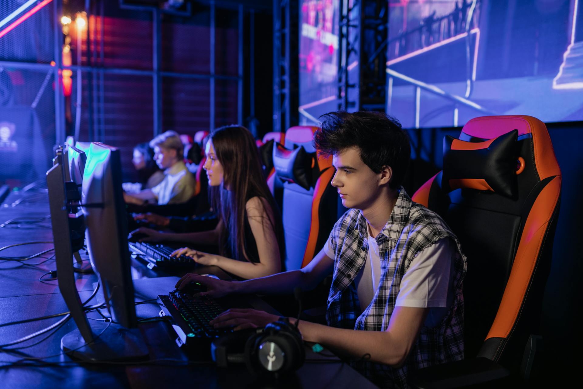 Gamers focused on a competitive esports event, showcasing teamwork and strategy.