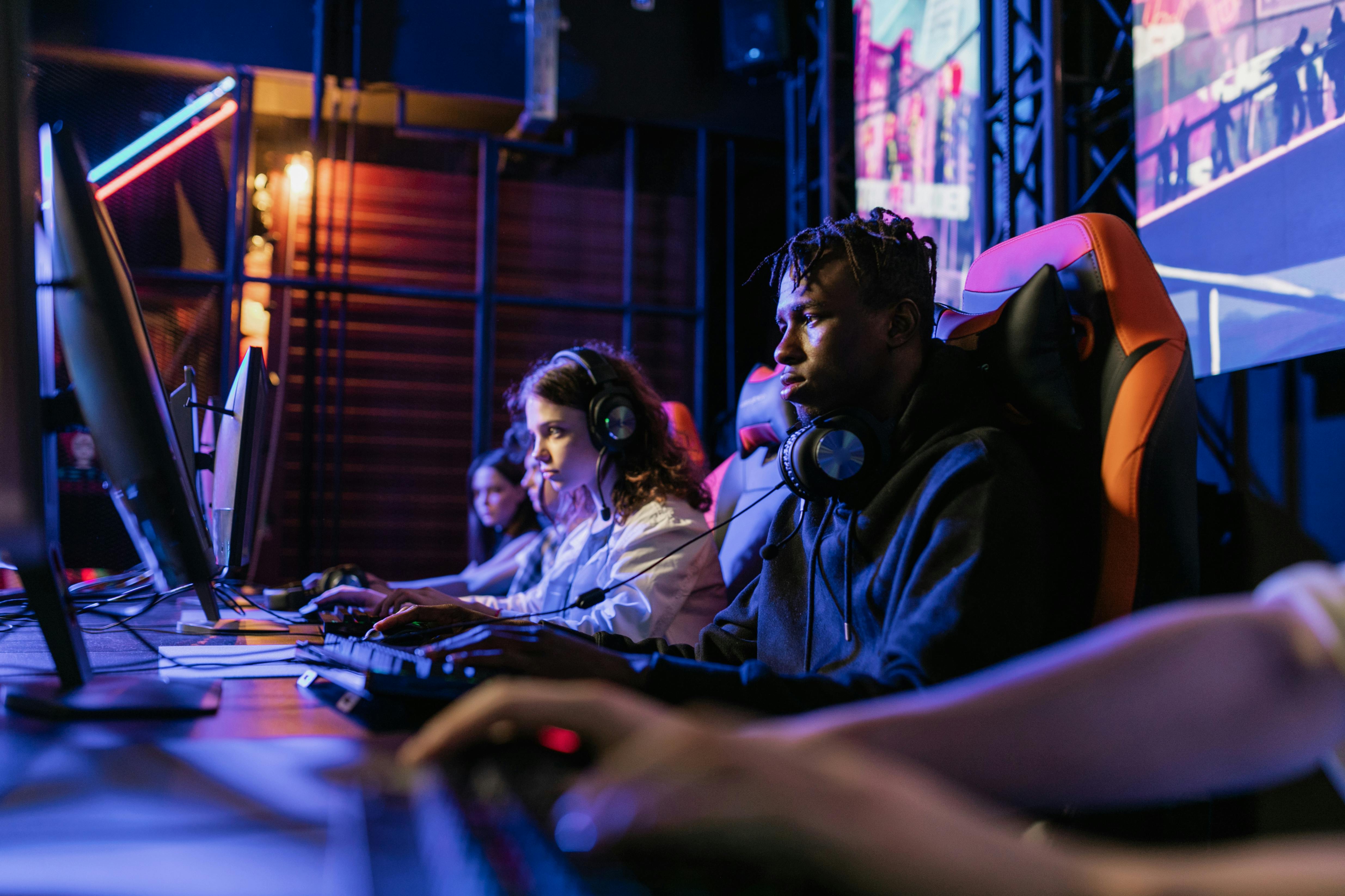 people sitting on black and orange gaming chairs