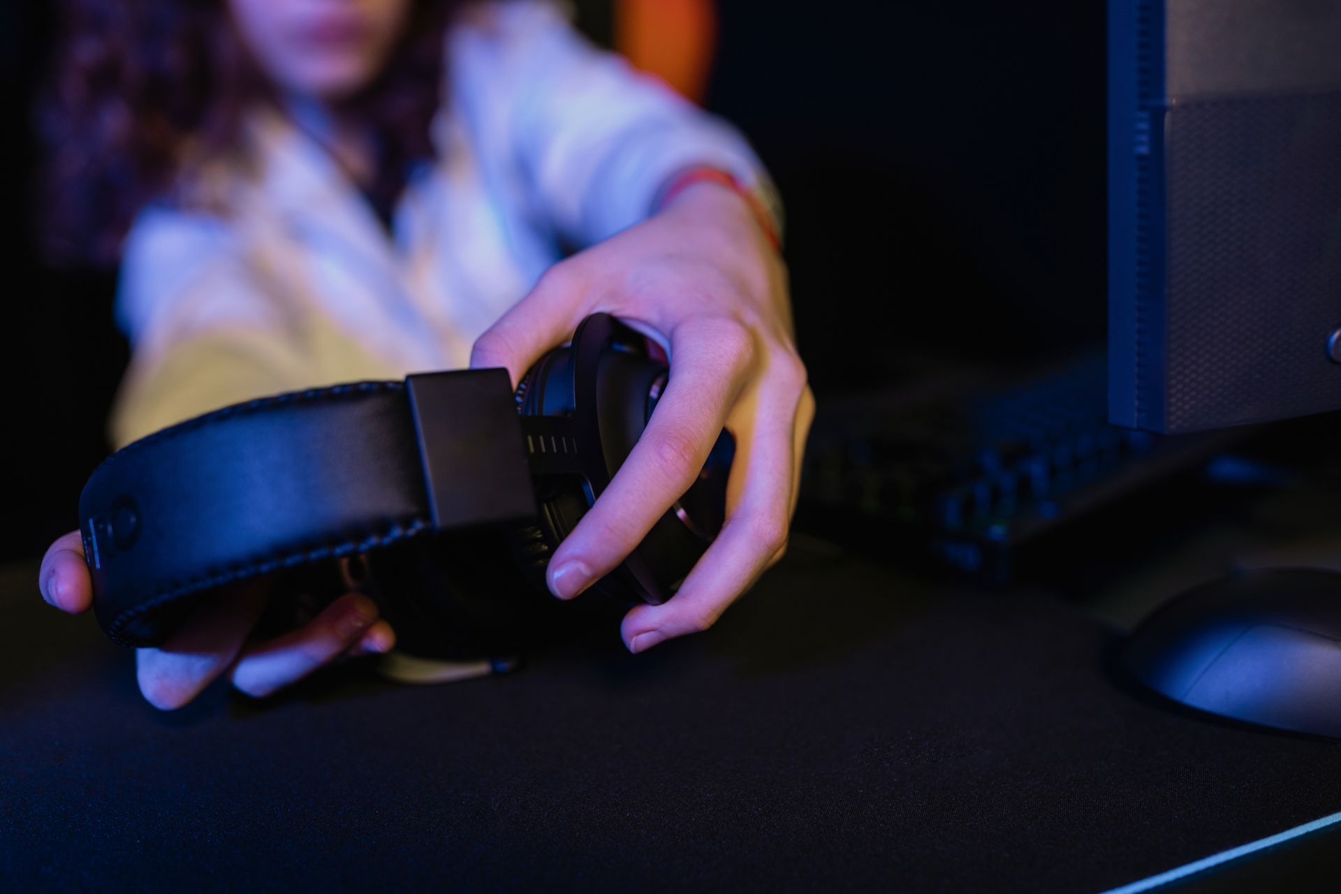 A Person's Hands Holding a Black Headset