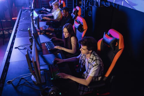 People Sitting on a Gaming Chair while Playing Video Games