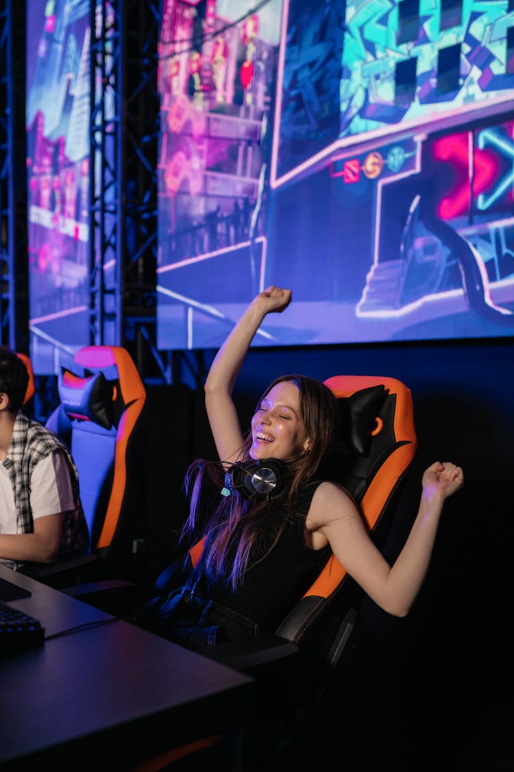 A Woman In Black Tank Top Sitting On A Gaming Chair