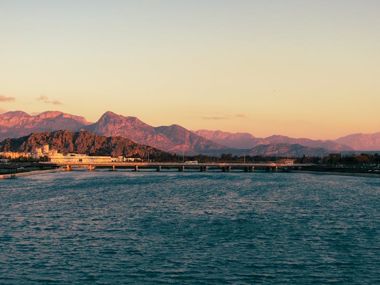 Bridge On River Overlooked By Mountain Range