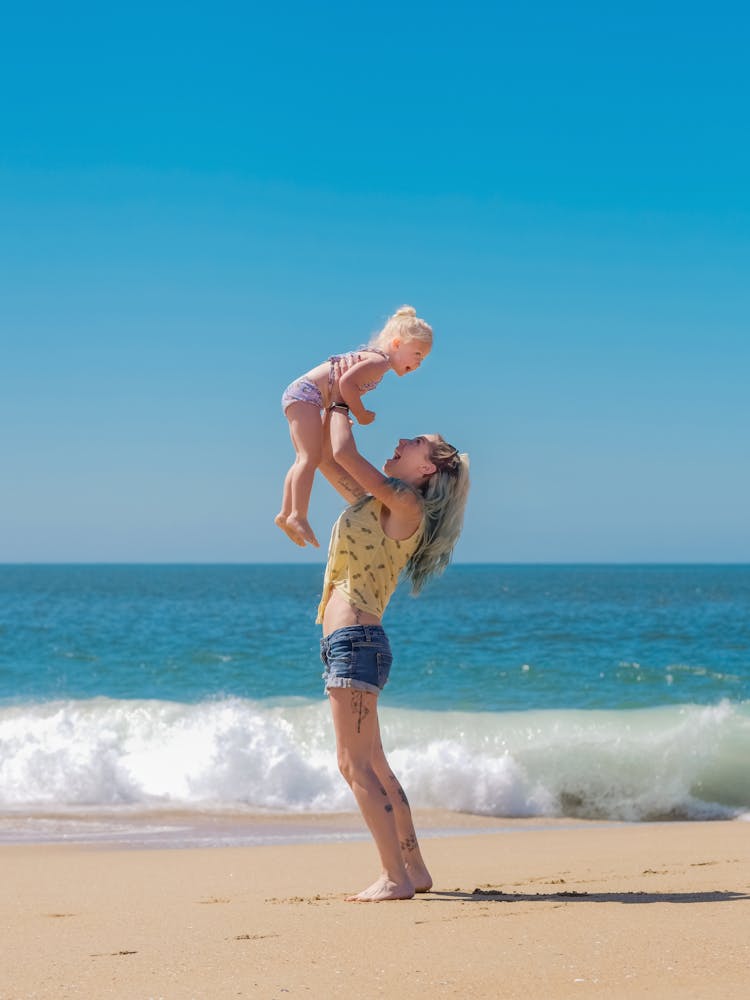 A Daughter And Her Mother Playing At The Beach