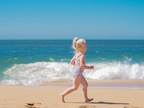 Photo of a Girl Running Near the Sea