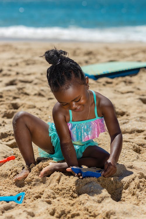 A Girl Playing with Brown Sand while Sitting