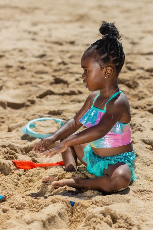 A Girl in Blue Swimwear Sitting on the Sand · Free Stock Photo