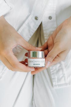 A close-up of hands holding a CBD capsule bottle, symbolizing health and wellness.