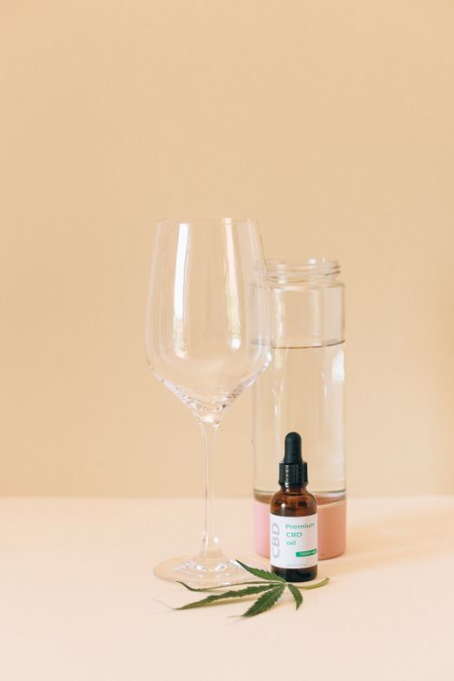 Free Minimalist still life of CBD oil with glass and cannabis leaf for natural wellness. Stock Photo