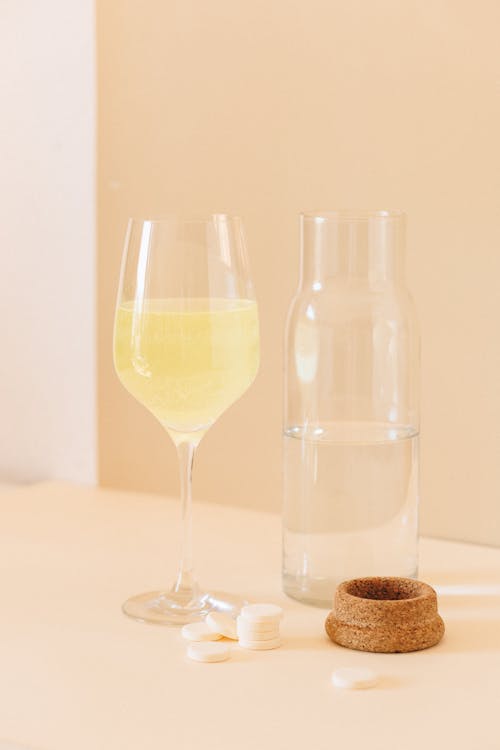 A Glass Near a Glass Jar and Tablets