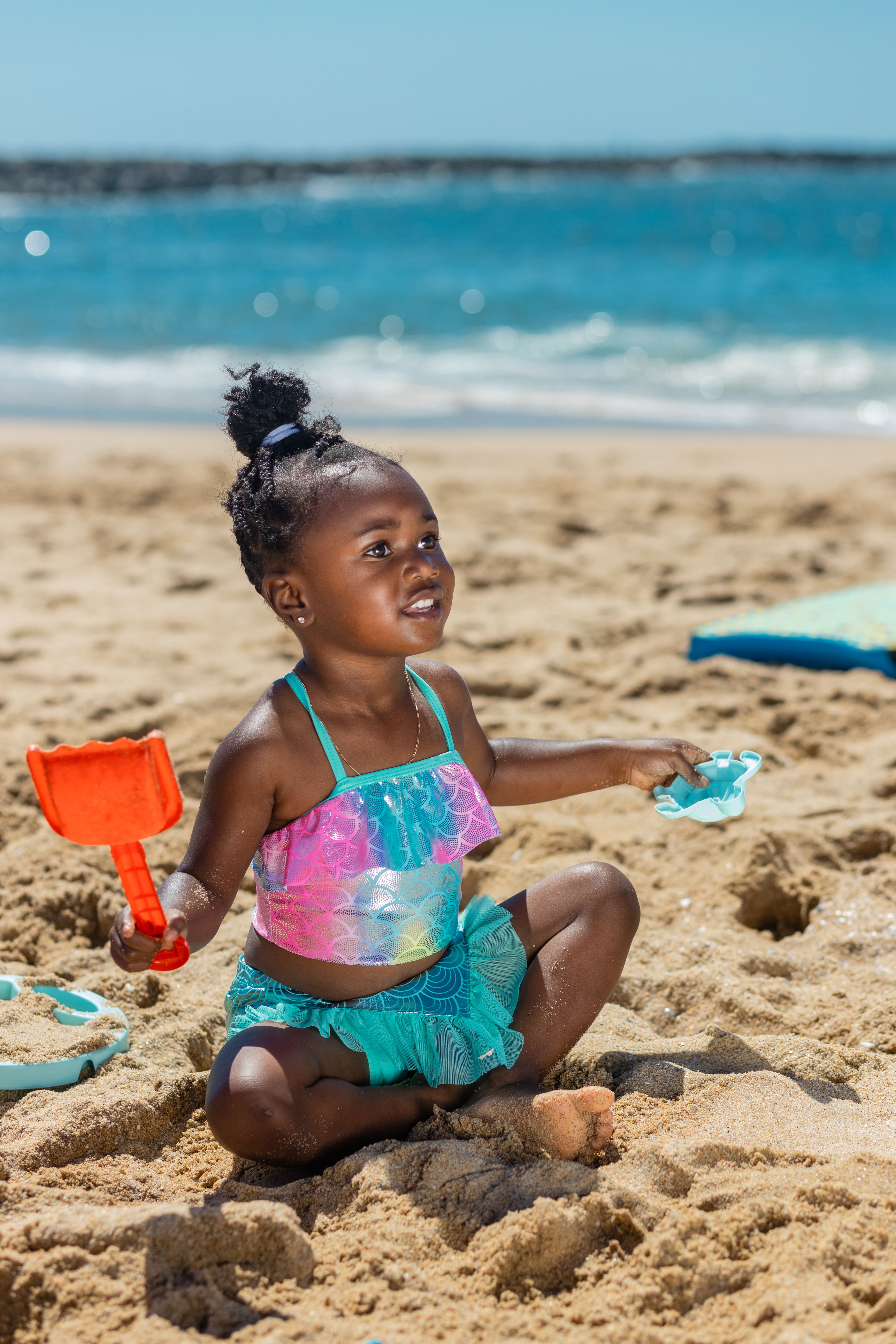 A Girl in Blue Swimwear Sitting on the Sand · Free Stock Photo
