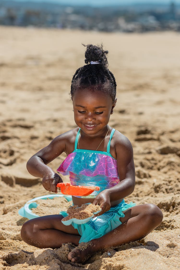 A Girl In Swimwear Playing Sand On The Beach