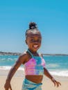 微笑的孩子在美人鱼泳装享受阳光明媚的海滩一天