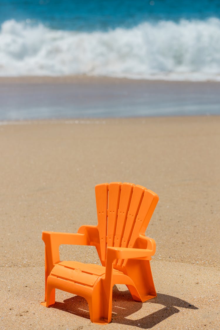 A Plastic Chair On Beach Sand