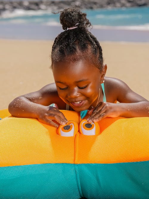 A Girl Looking at an Orange and Blue Toy