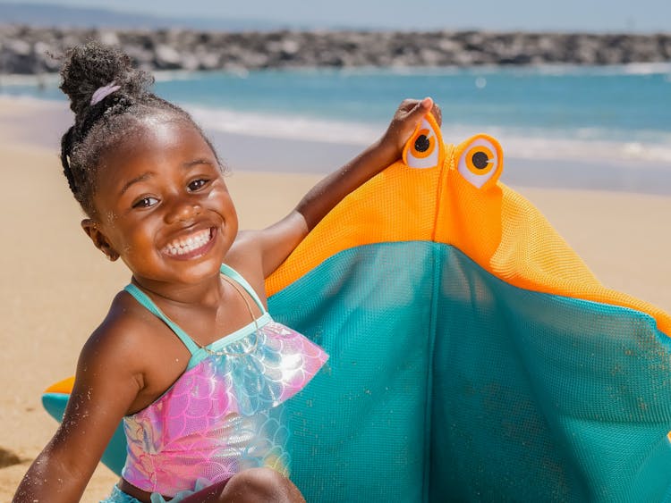 A Girl Smiling While Holding Her Toy