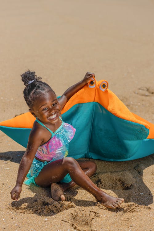 Free A Young Girl Sitting on the Beach Sand Stock Photo