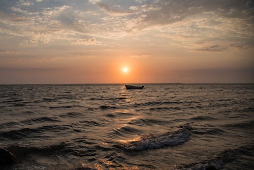 Silhouette of Boat on Sea During Sunset