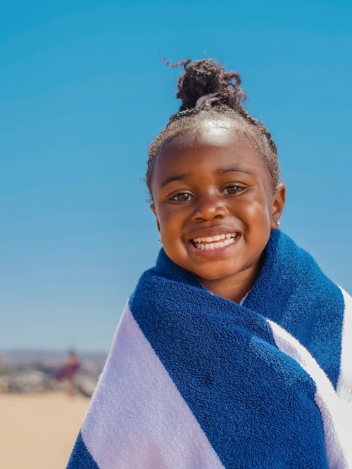 A Girl Smiling while Wearing a Beach Towel