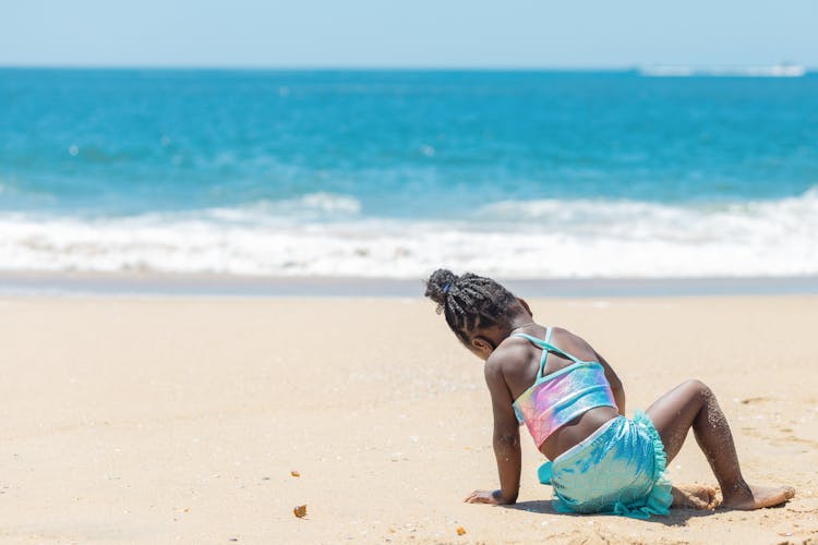 A Child Playing On Beach Shore