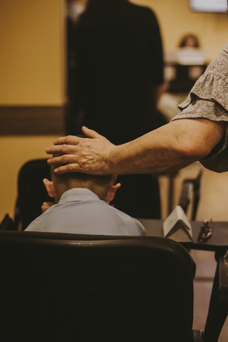 Back View Of A Womans Hand On A Boys Head 