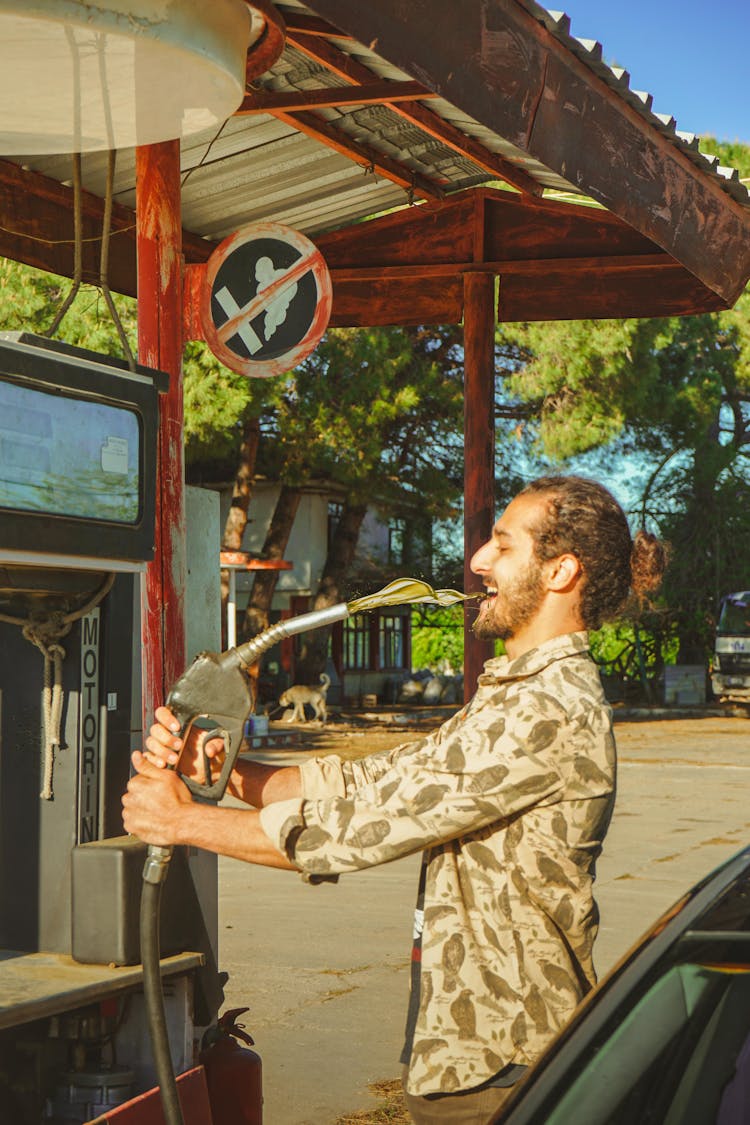 Man At An Abandoned Petrol Station Making A Joke Of Refueling