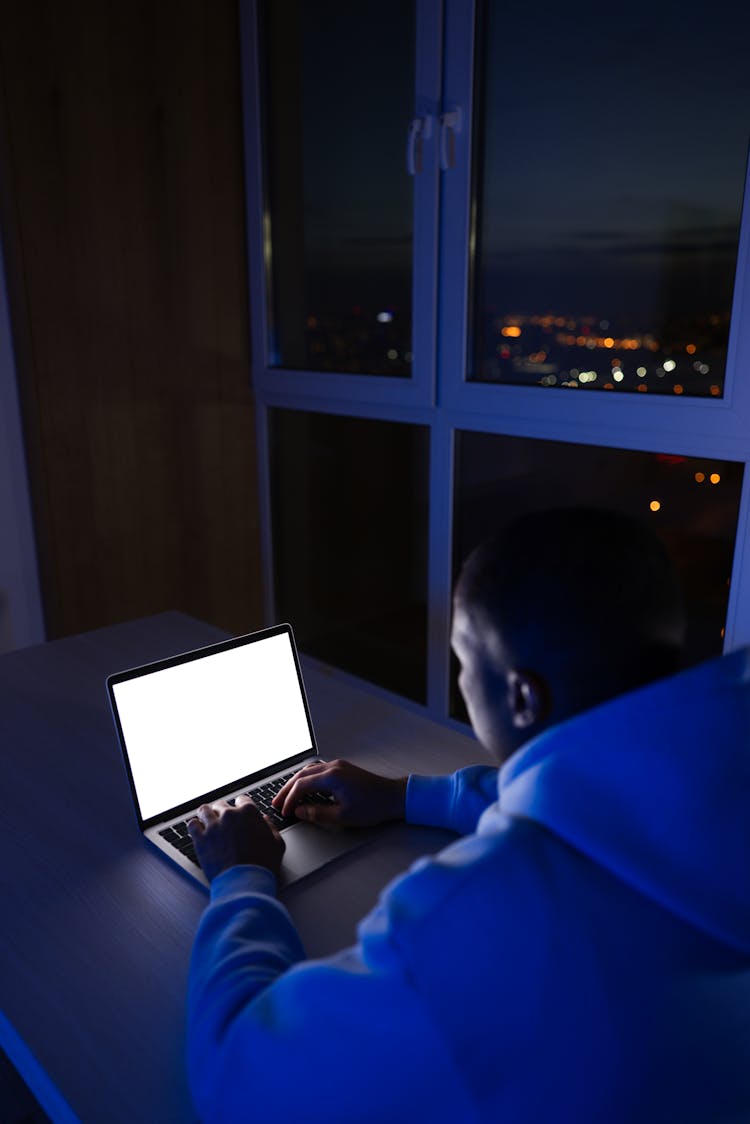 A Man Typing On A Laptop 