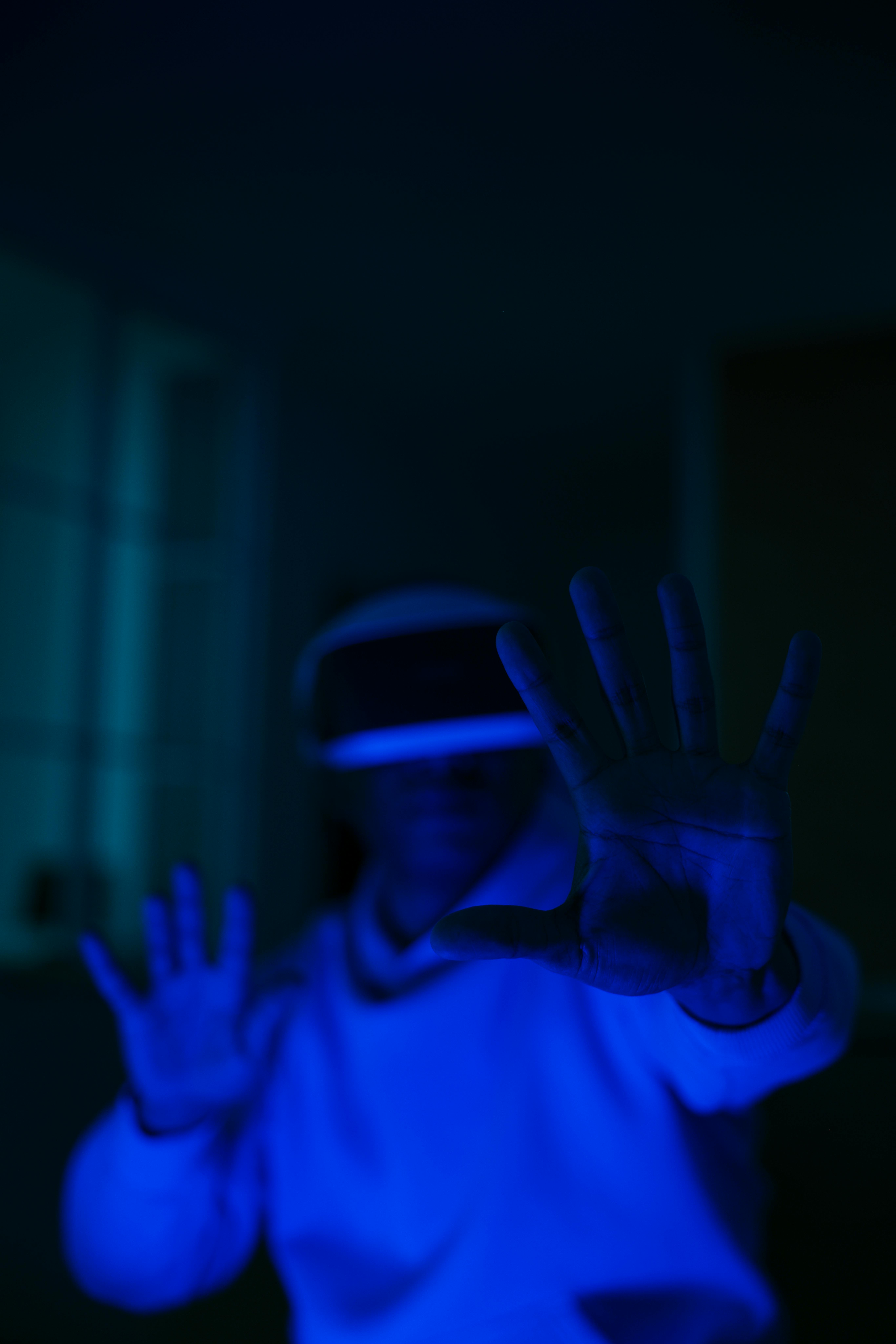 person wearing virtual reality glasses in a room with blue light