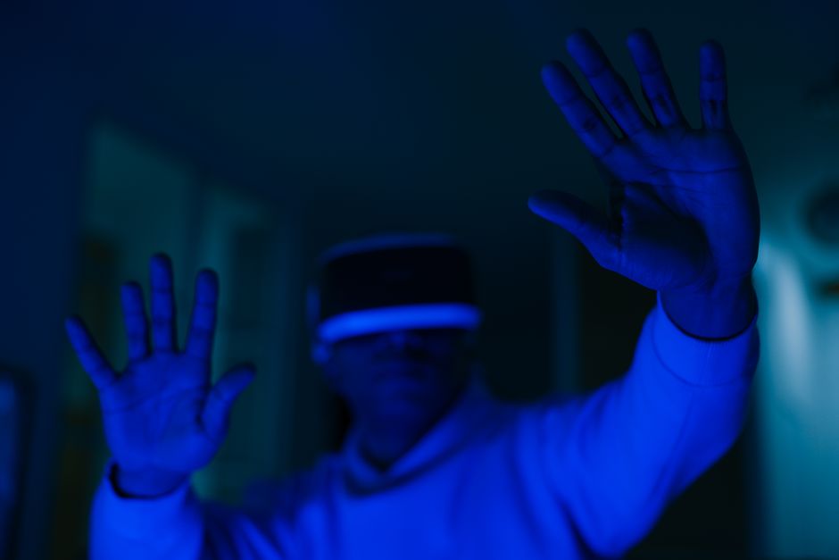 Bărbat purtând căști VR cu iluminare albastră - experiența HFR în realitatea virtuală