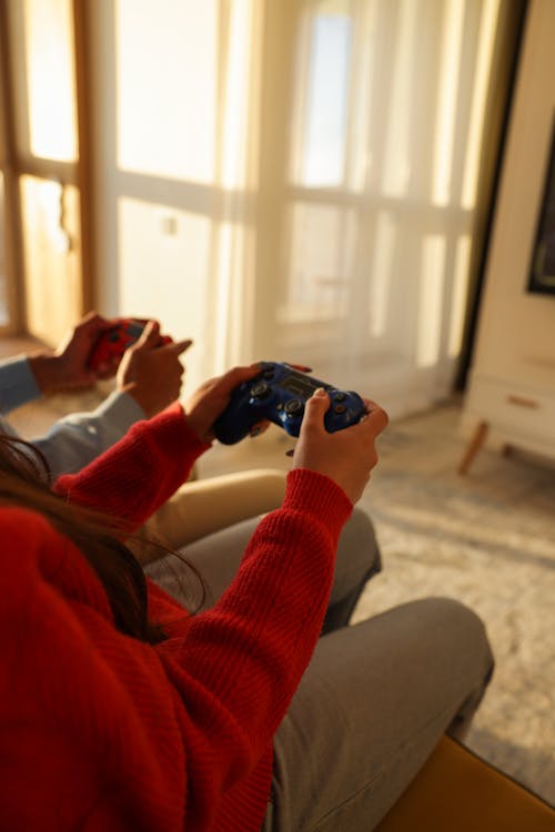 People Sitting on Sofa Playing Video Game