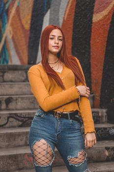 Portrait of a fashionable young woman posing by colorful graffiti in Barranco, Lima, Peru.