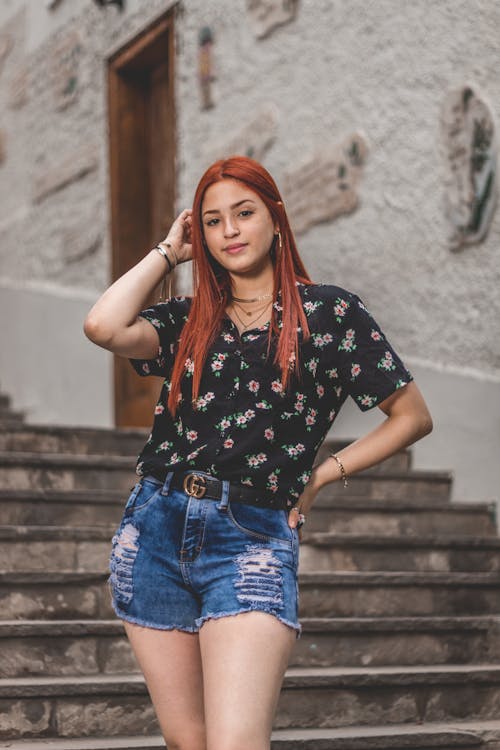 Woman in Floral Top and Denim Shorts