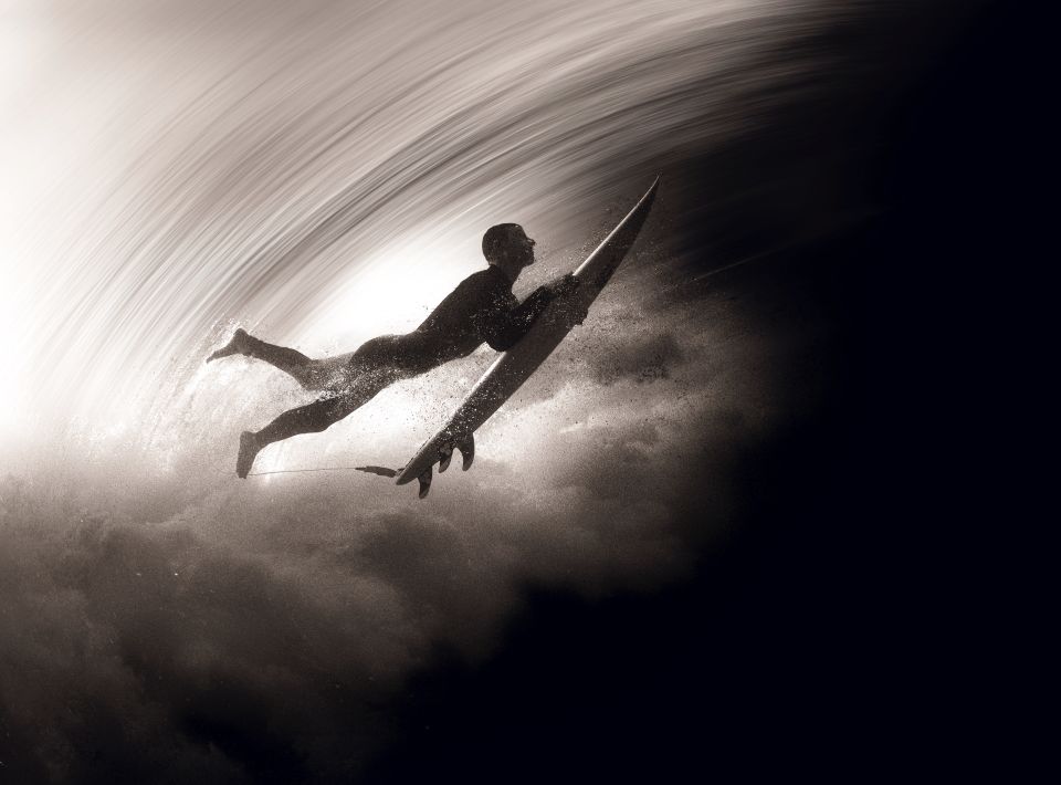Surfer duck diving under a breaking wave on the way out