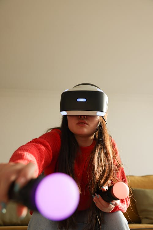 Woman in Red Knit Sweater Wearing Black and White Virtual Reality Headset