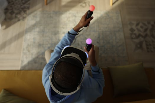 Top view of an adult playing with a VR headset and controllers indoors, emphasizing immersive gaming.