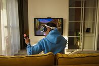 Man in Blue Hoodie Sitting on Brown Couch