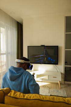 Adult using a virtual reality headset indoors, immersed in a gaming experience with a large TV display.