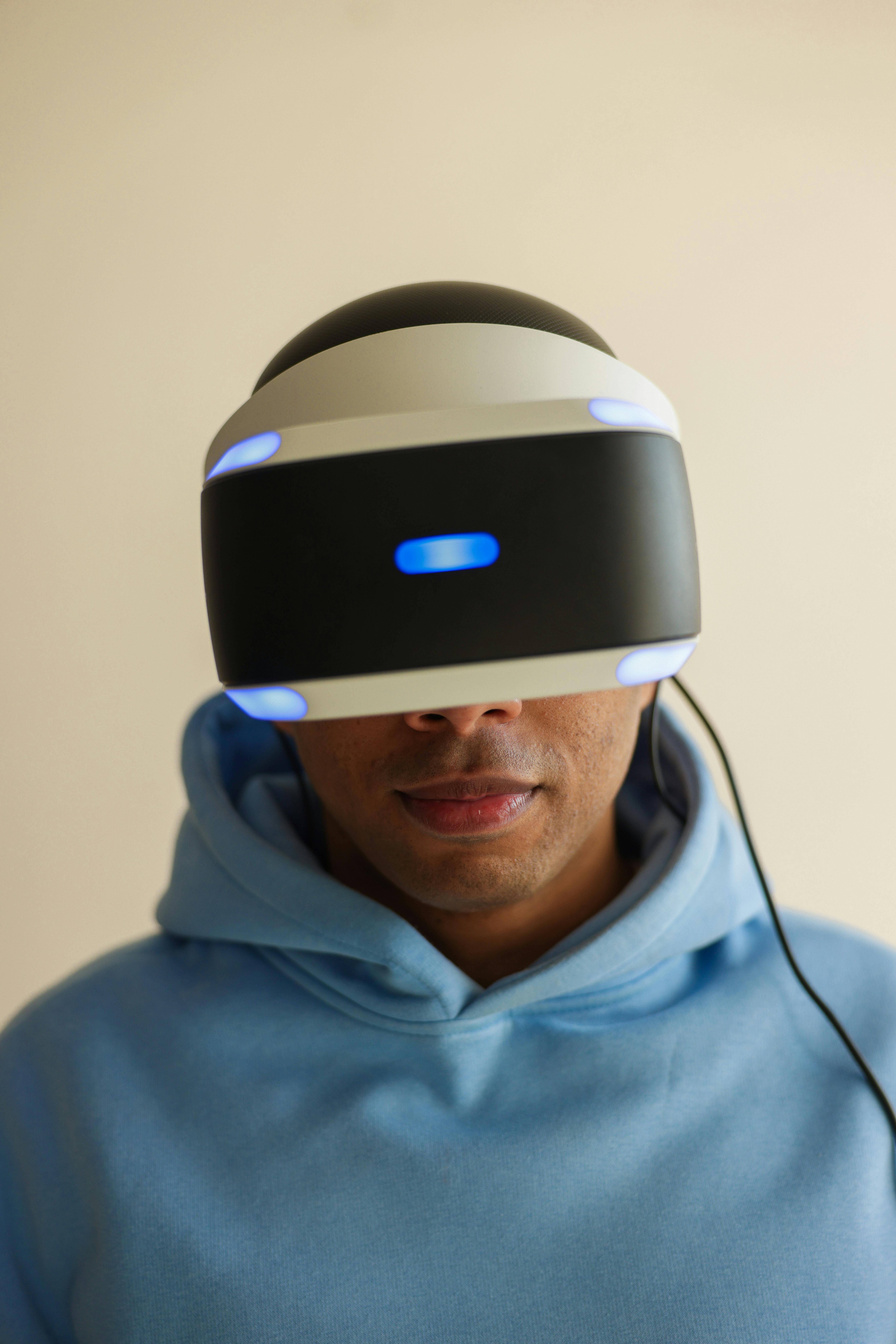 man in blue hoodie wearing black and white vr goggles