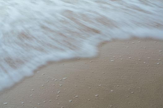 Serene close-up of ocean waves flowing over a sandy beach, perfect for relaxation themes.