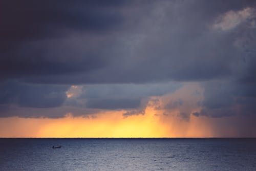 Free Body of Water Under Cloudy Sky during Sunset Stock Photo