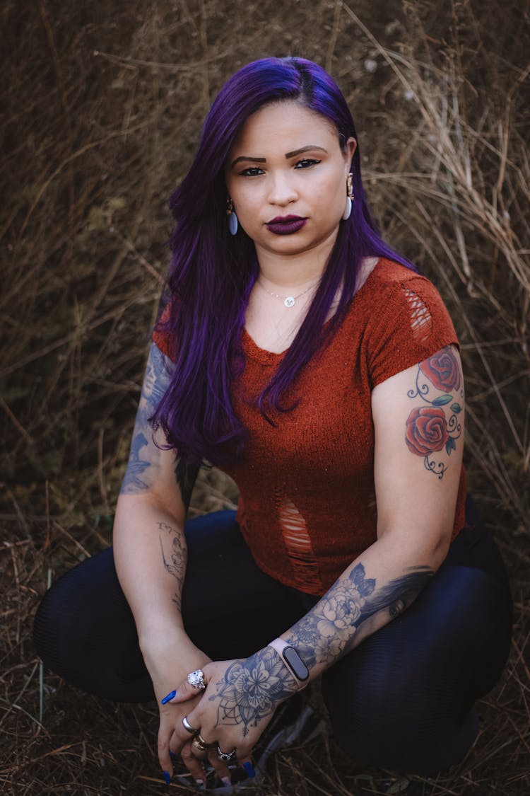 Portrait Of A Woman With Tattoos Sitting In Hay