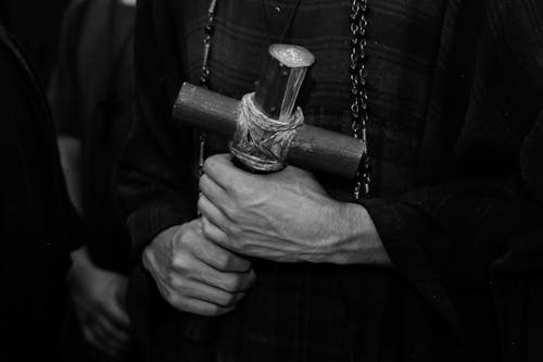 Grayscale Photo of a Person's Hands Holding a Cross