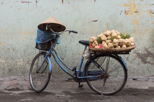 Vintage Bike with Conical Hat and Vegetables