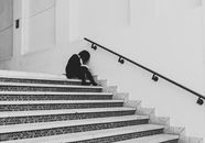 Man in Black Jacket Sitting on Staircase