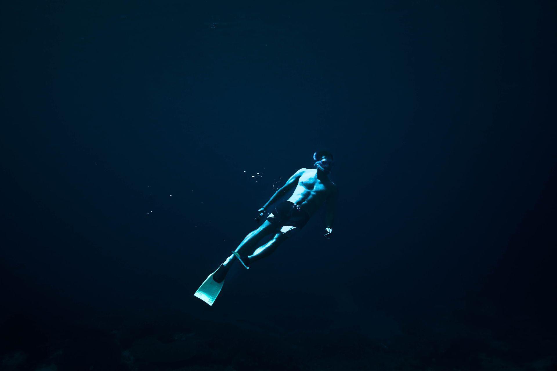 A free diver explores the deep ocean's blue waters, showcasing underwater freedom.