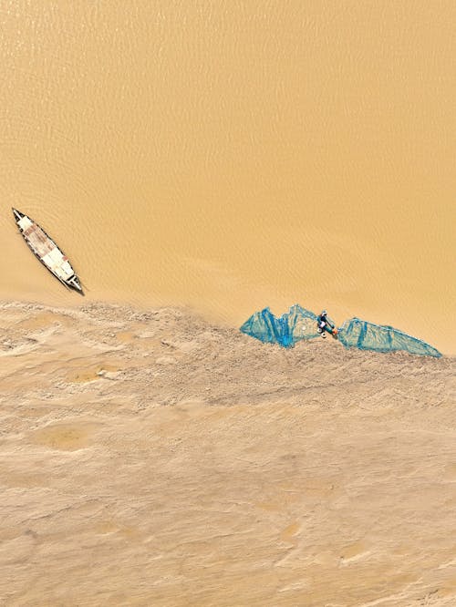 Aerial View of a Beige Flood Water and Sand with a Canoe and Blue Net