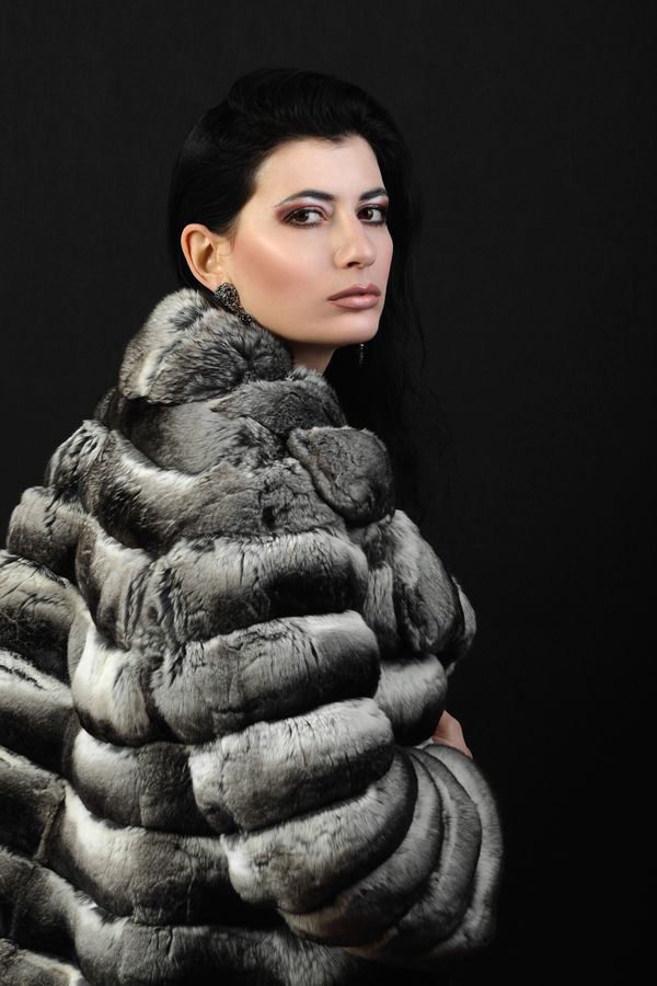 Woman in a faux fur coat over a black dress