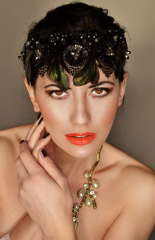 Free Glamorous portrait of a woman wearing a beaded headpiece and pearl necklace in a studio setting. Stock Photo
