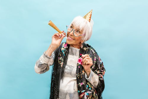 หญิงวัยงามสวมหมวกปาร์ตี้อย่างร่าเริง